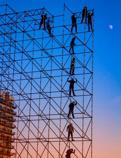 silhouette-or-construction-workers-on-stage-scaffo-2021-09-01-18-49-50-utc